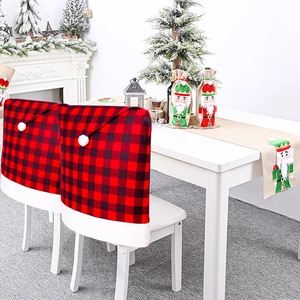 Red and black buffalo plaid Santa hat chair covers with white plush balls for Christmas decor
