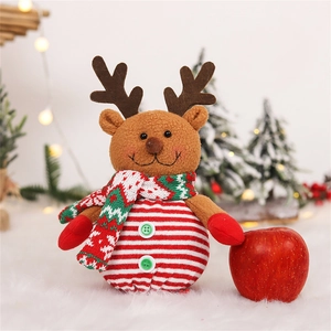 Plush Christmas reindeer doll with knitted scarf and red nose on white faux fur carpet