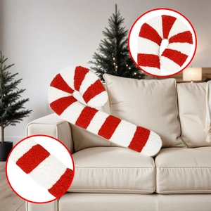 Detail of red and white striped candy cane plush pillow on sofa with festive background