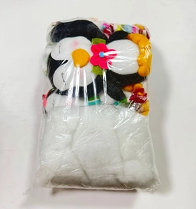 Primer plano de pingüino de peluche con flor rosa en bolsa de plástico transparente