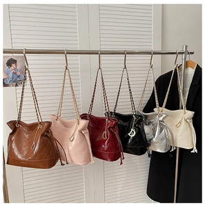 Detailed row of quilted leather bucket bags with gold chain straps in multiple colors