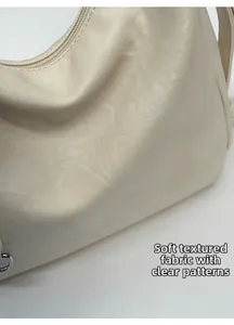 Detail of soft cream PU leather texture and silver zipper on the versatile shoulder bag