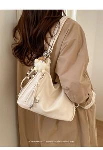 Minimalist beige hobo bag with vintage leather texture and cute plush charm detail