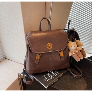 Detail of vintage brown backpack featuring matte PU leather and a golden metal clasp