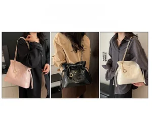 Quilted bucket bag with chain strap and gold D charm in pink, black, and white colors