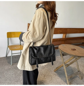 Retro black faux leather crossbody bag worn by a model in a minimalist interior setting