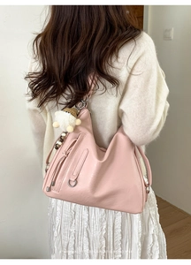 Pink Hobo shoulder bag with cute plush pendant shown on a model for a retro vibe