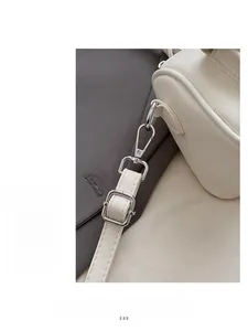 Close-up of premium silver-tone hardware and precise stitching on white leather bag