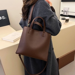 Deep brown lychee textured leather tote bag with top handles and adjustable strap