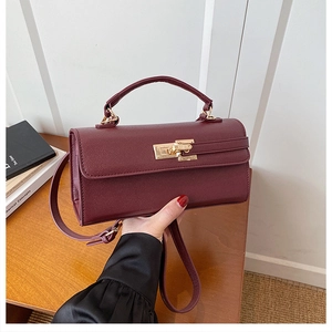 Vue détaillée du sac bandoulière vintage bordeaux avec fermoir rotatif doré