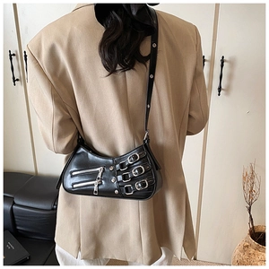Detail of black punk shoulder bag with triple silver buckles and metal zippers