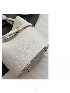 Detailed macro view of off-white lychee pattern leather bucket bag with silver hardware