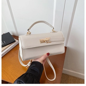 Détail du sac à main en cuir blanc crème avec fermoir doré et poignée supérieure ronde