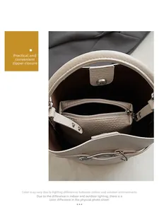 Detail of cream bucket bag showing interior zippered pouch and magnetic closure