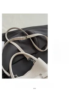 Detailed close-up of white lychee pattern leather shoulder strap with silver buckle