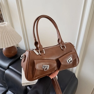 Detail of vintage brown PU leather handbag featuring dual pockets and silver buckles