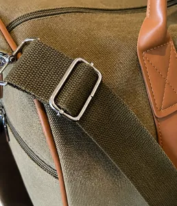 Detail der Reisetasche aus Segeltuch mit silberner Metallschnalle und robustem Gurtband