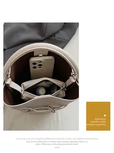 Top view of cream bucket bag interior showing spacious room with a zipper pouch and phone