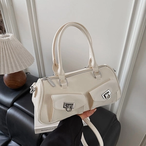 Detail of off-white leather Boston bag featuring dual front pockets and silver buckles