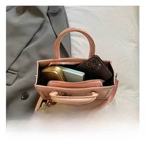 Pink patent leather handbag detail showing internal capacity for phone and cosmetics