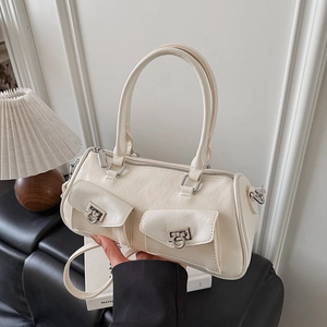 Close-up of cream white cylindrical baguette bag with silver hardware and front pockets