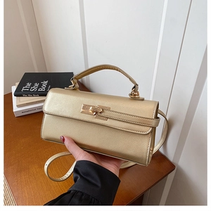 Détail de la texture cuir grainé doré champagne et de la poignée supérieure du sac à main