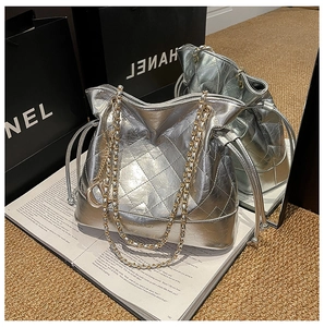 Detail of silver quilted bucket bag with gold chain strap and metallic D charm