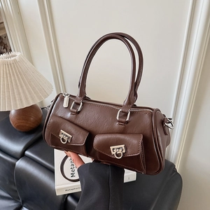 Detail of tan brown boston bag showing lychee grain texture and silver horseshoe buckles