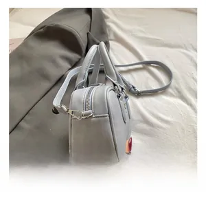 Détail de la fermeture éclair argentée et boucle en métal du sac bowling bleu clair