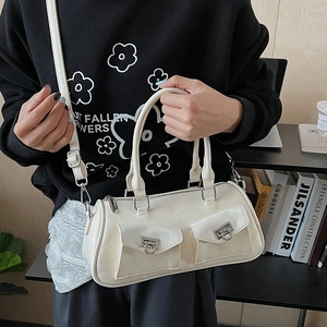 Detail of white leather baguette bag with dual front pockets and silver hardware on a model
