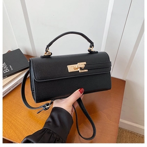 Détail du sac à main noir en cuir croisé avec fermoir tournant doré et anse
