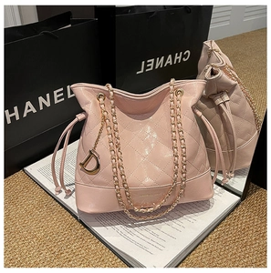 Detailed view of pink quilted chain bucket bag with golden D charm and drawstring closure