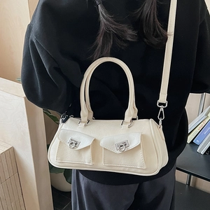 Detail of cream-white Boston bag featuring silver horseshoe buckles and dual front pockets