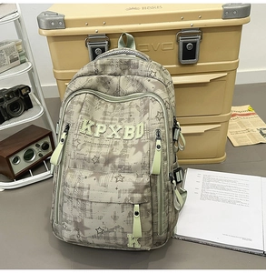 Detailansicht eines stylischen Rucksacks mit Karomuster und Stickerei auf einem Vintage-Tisch