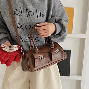 Brown vintage Boston bag with dual front pockets and metallic horsebit clasps