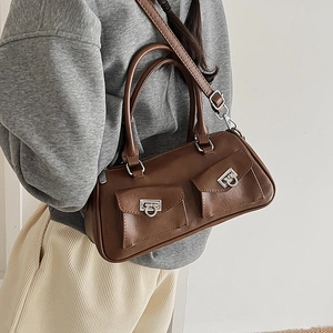 Detailed close-up of brown faux leather bag featuring silver Gancini-style metal buckles