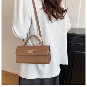 Détail d'un sac bandoulière en cuir Saffiano marron avec finitions dorées et poignée