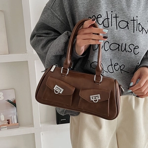 Detail of vintage brown matte leather handbag with double pockets and silver metal rings