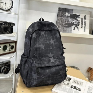 Detail of grey starry print backpack on desk with artistic props and vintage camera
