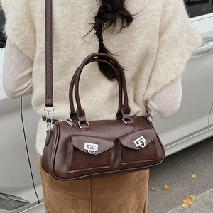 Detail of vintage brown baguette bag featuring silver buckles and double front pockets