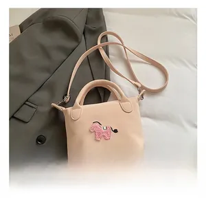 Détails d'un mini sac à bandoulière rose avec un écusson poney en peluche et anse
