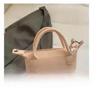 Détail du sac seau en cuir rose avec broderie de caniche et fermeture éclair métallique
