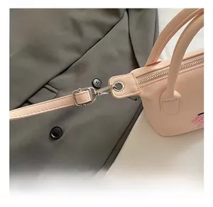 Détails des crochets métalliques argentés et de la quincaillerie du sac en cuir rose
