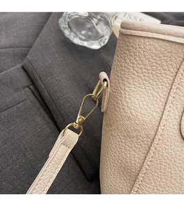 Detailed close-up of premium lychee grain leather and gold metal hardware hooks