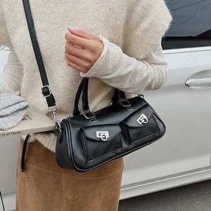 Detail of black matte leather handbag featuring twin front pockets and silver ring buckles