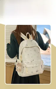 Sac à dos d'école blanc avec motifs papillons gris et breloque ours sur modèle