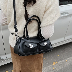 Detail of a black leather handbag featuring two front pockets and silver ring buckles