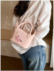 Détail d'un sac seau rose avec broderie chiot mignonne et bandoulière réglable pratique