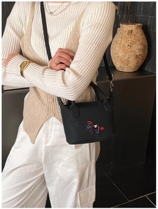 Détail du sac seau en cuir noir avec broderie cheval raffinée et finitions argentées