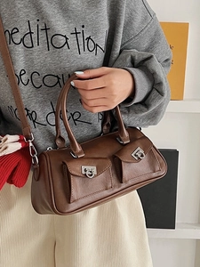Brown retro baguette handbag with silver buckle and front pockets shown on a model